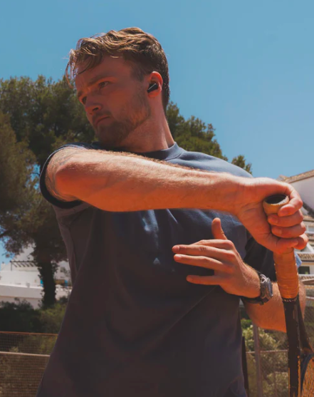 Mand der spiller tennis med Wavell 3 Pro in-ear høretelefoner på i sort