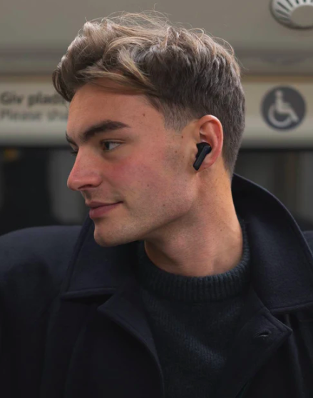 Mand i metroen med Wavell 3 Pro in-ear høretelefoner på i sort